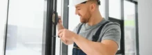 Trabalhador realizando manutenção predial em esquadria de janela
