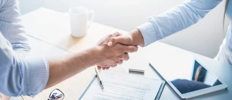 Profissionais apertando as mãos, representando uma parceria, simbolizando as vantagens da terceirização de serviços