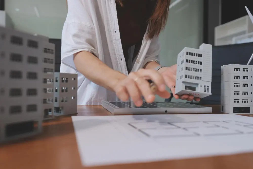 Profissional analisando maquetes de prédios residenciais e comerciais para administração de condomínio