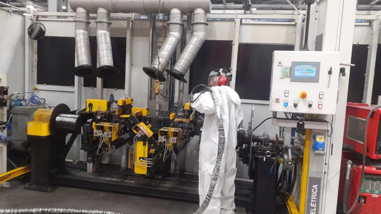 Operador realizando limpeza com gelo seco em equipamento industrial, removendo resíduos sem uso de água ou produtos químicos